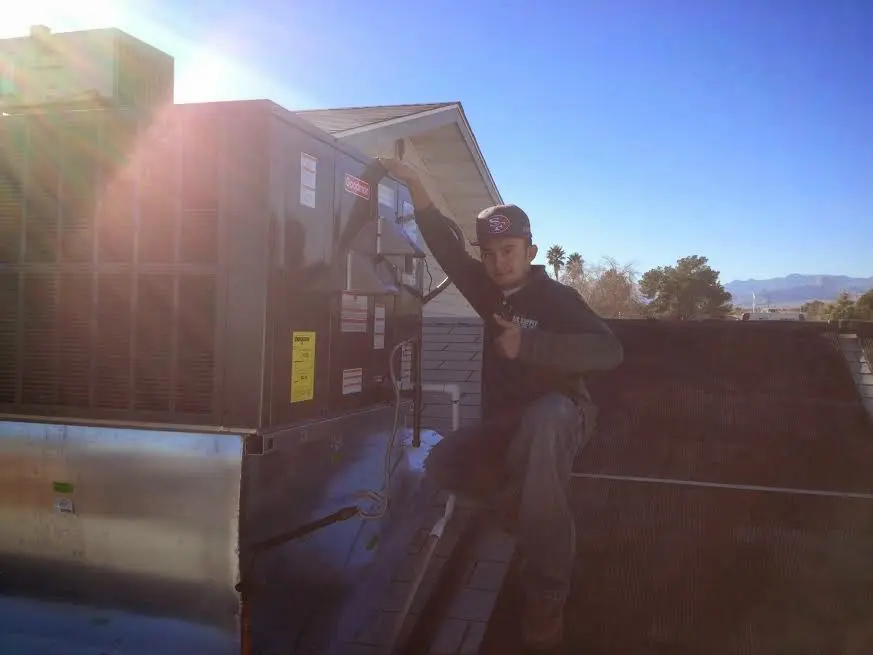 HVAC technician performing HVAC Inspection on a rooftop unit in Belfast